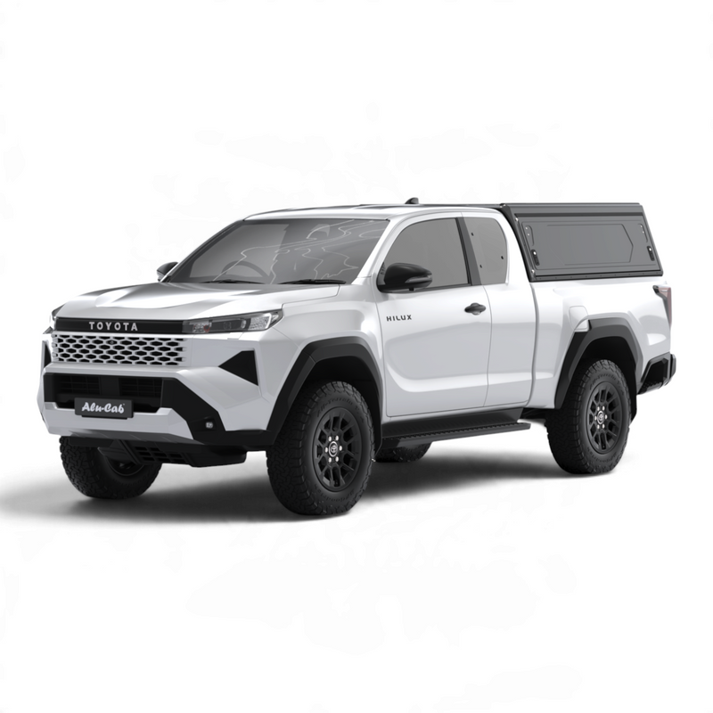 Main view of the Alu-Cab Contour Canopy, without side windows, for the 2026+ Toyota Hilux Extra Cab, mounted on the vehicle, on a white background