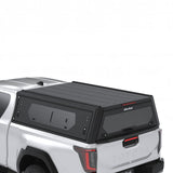 Arial view of the Alu-Cab Contour Canopy, with side windows, for the 2026+ Toyota Hilux Extra Cab, mounted on the vehicle, on a white background