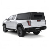 A white Toyota Hilux 2026+ Extra Cab with a Alu-Cab Explorer Canopy, with a smooth finish, over the bed, shown from a low three-quarter rear angle on a white background.