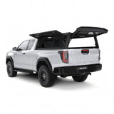 An Alu-Cab Explorer Canopy, with a smooth finish and gullwing doors opened up, on a Toyota Hilux 2026+ Extra Cab on a white background.