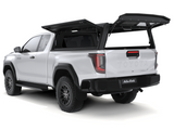 An Alu-Cab Explorer Canopy, with a smooth finish and gullwing doors opened up, on a Toyota Hilux 2026+ Extra Cab on a white background.