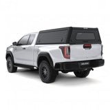 A white Toyota Hilux 2026+ Extra Cab with a Alu-Cab Explorer Canopy, with a tread plate finish, over the bed, shown from a low three-quarter rear angle on a white background.