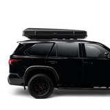 A side view of a Black SUV with an iKAMPER Skycamp 4.0 Quad, 4 sleeper rooftop tent on a gray background