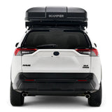 A white Toyota RAV4 XL8 Hybrid SUV shown from the rear, featuring a black Hardshell iKAMPER Skycamp 4.0 Trio, 3 sleeper, rooftop tent mounted on top