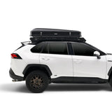 A white compact SUV shown in side profile with a black Hardshell iKAMPER Skycamp 4.0 Trio, 3 sleeper, rooftop tent mounted on a Roof Rack , photographed on a clean white studio background.