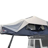 A close up of the Front Runner Feather-Lite II Rooftop Tent in an opened up position, on a Campx4 rental vehicle, on a white background
